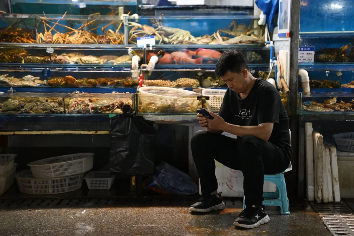 A vendor waits for customers at a wholesale fish market in Beijing on Aug. 24, 2023. China on Aug. 24 banned all Japanese seafood imports over what it said was the "selfish" release of wastewater from the crippled Fukushima nuclear plant. (Greg Baker/AFP via Getty Images)