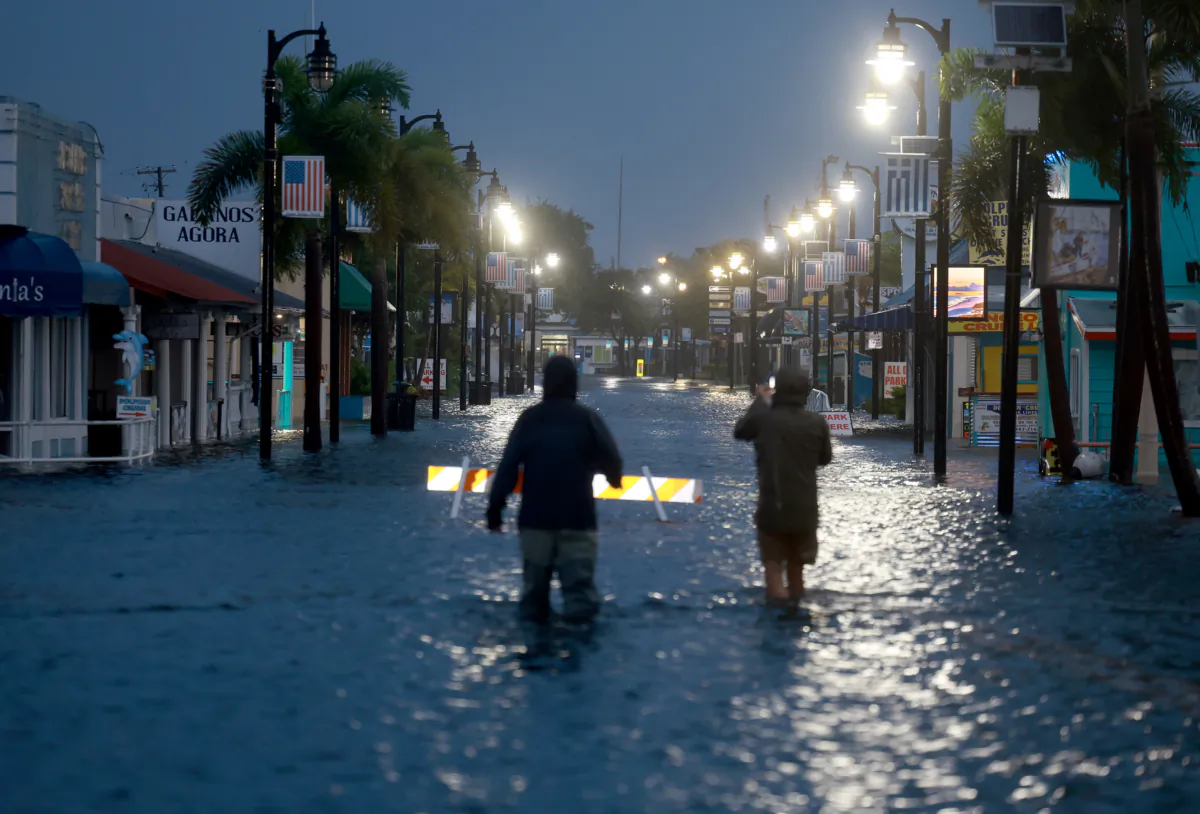 Reporters wade through flood waters as it inundates the downtown area after Hurricane Idalia passed offshore in Tarpon Springs, Fla., on Aug. 30, 2023. (Joe Raedle/Getty Images)