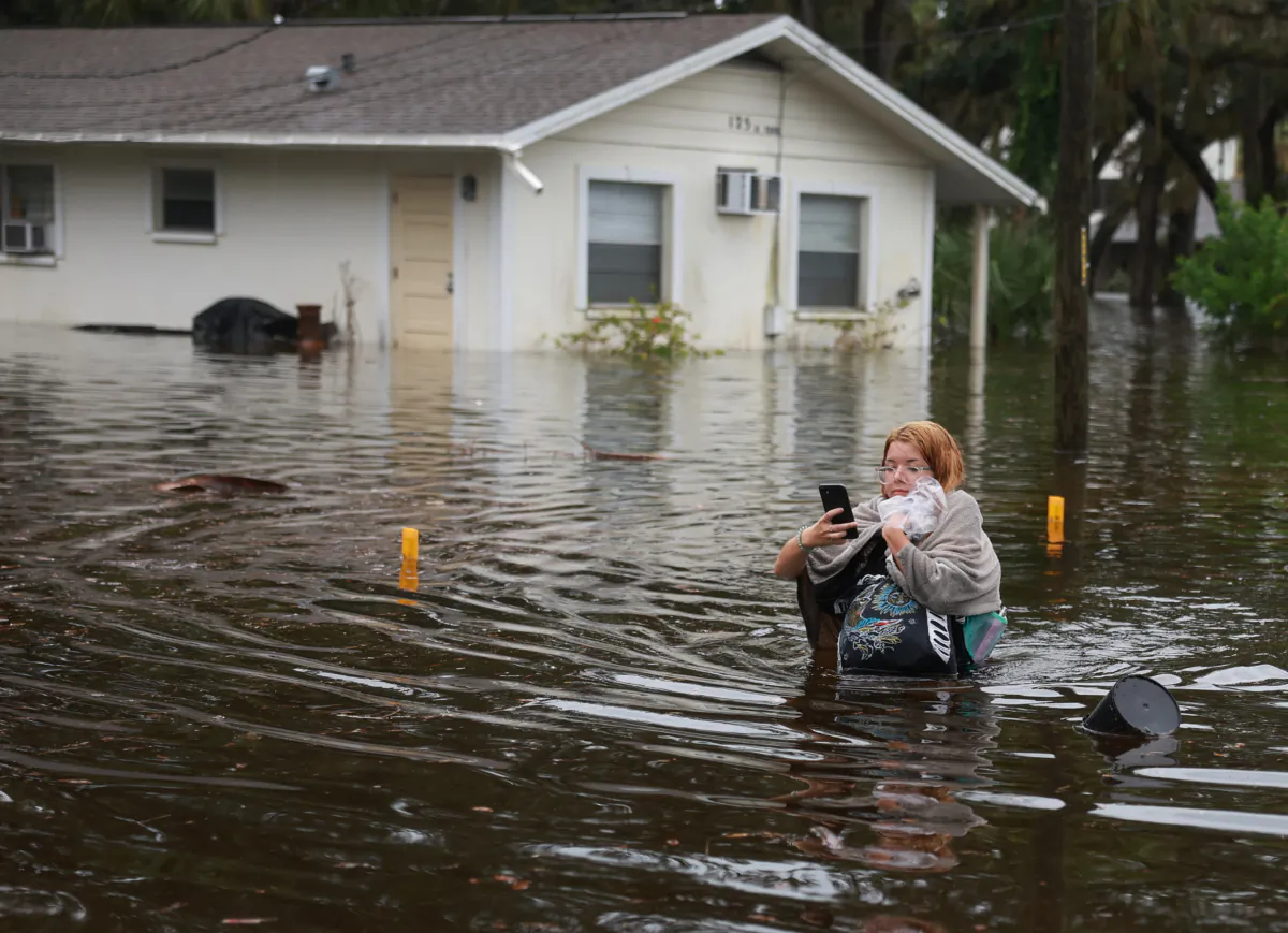 Makatla Ritchter wades through flood waters after having to evacuate her home when the flood waters from Hurricane Idalia inundated it on August 30, 2023 in Tarpon Springs, Florida. Hurricane Idalia is hitting the Big Bend area of Florida. (Photo by Joe Raedle/Getty Images)