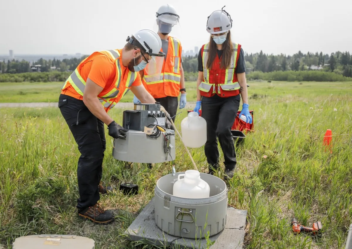 University of Calgary researchers check monitoring equipment as they track traces of COVID-19 in the wastewater system in Calgary on July 14, 2021. (The Canadian Press/Jeff McIntosh)