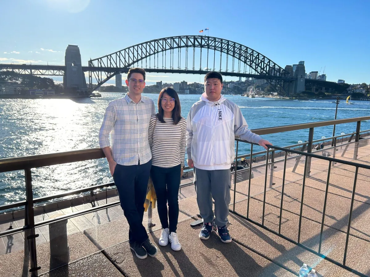 Allen Wang with his sister and brother-in-law posed in front of the Sydney opera house. (supplied)
