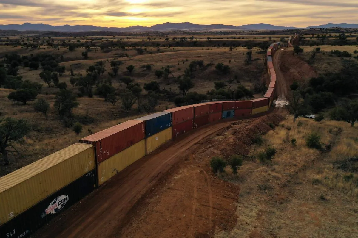 A border wall constructed of shipping containers and topped with concertina wire built on federal land, as directed by former Arizona Republican Gov. Doug Ducey, stands along the U.S.–Mexico border in the Coronado National Forest near Hereford, Ariz., on Dec. 20, 2022. (Patrick T. Fallon/AFP via Getty Images)