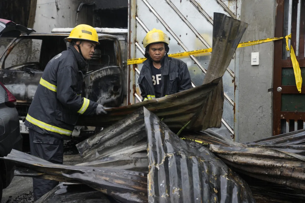 Firemen arrange steel sheets from a factory that caught fire in Quezon city, Philippines, on Aug. 31, 2023. (Aaron Favila/AP Photo)