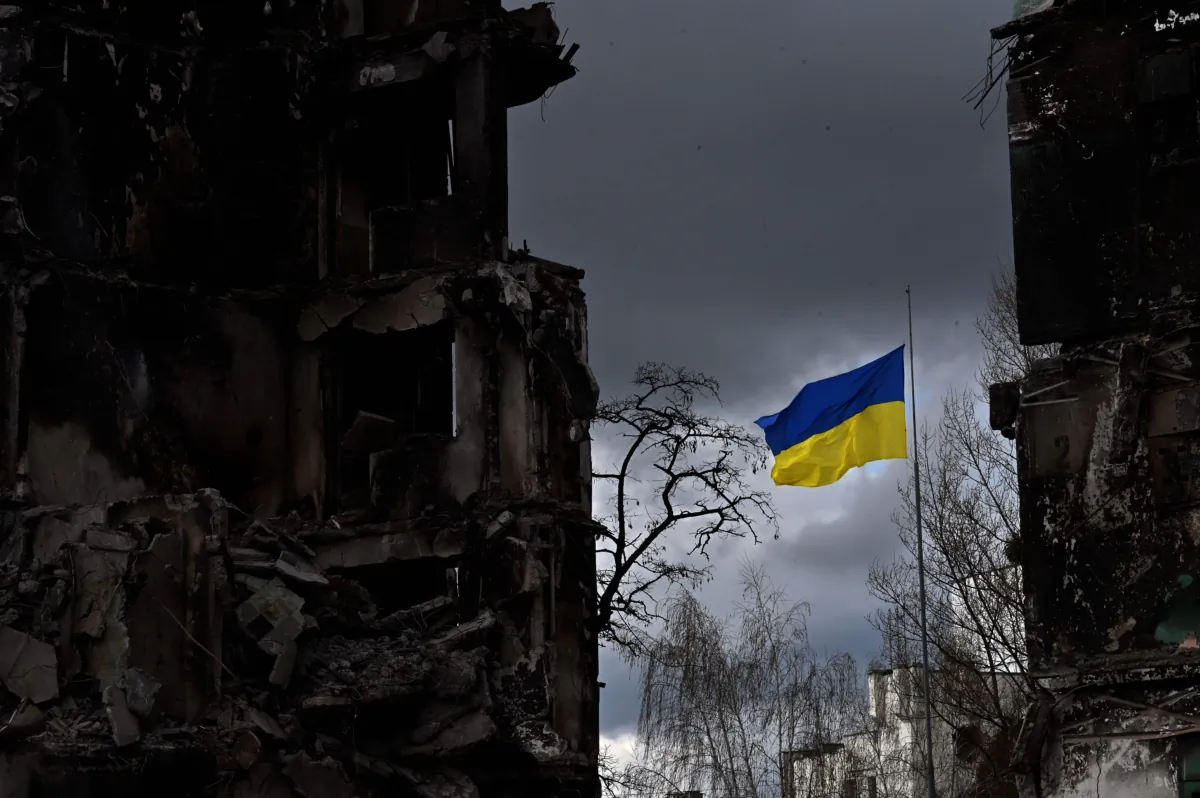 The Ukrainian flag flutters between buildings destroyed in bombardment, in the Ukrainian town of Borodianka, in the Kyiv region, on April 17, 2022. (Sergei Supinsky/AFP via Getty Images)