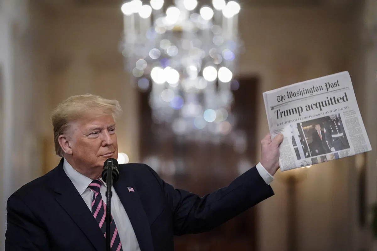 President Donald Trump holds a copy of The Washington Post as he speaks in the East Room of the White House one day after the U.S. Senate acquitted on two articles of impeachment, in Washington on Feb. 6, 2020. (TNS)