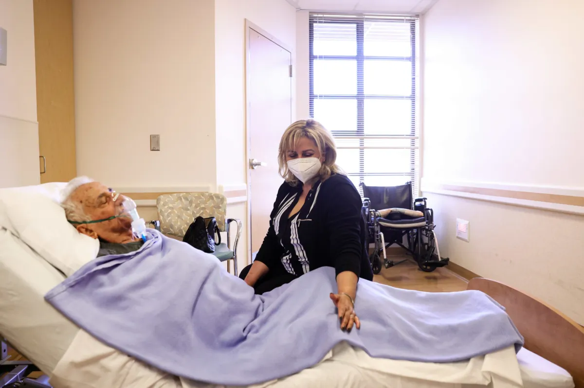 Resident Hanna Nasi is visited by daughter Surab Nasrallah on the first day of in-room family member visits at the Ararat Nursing Facility in the Mission Hills neighborhood in Los Angeles on March 24, 2021. (Mario Tama/Getty Images)