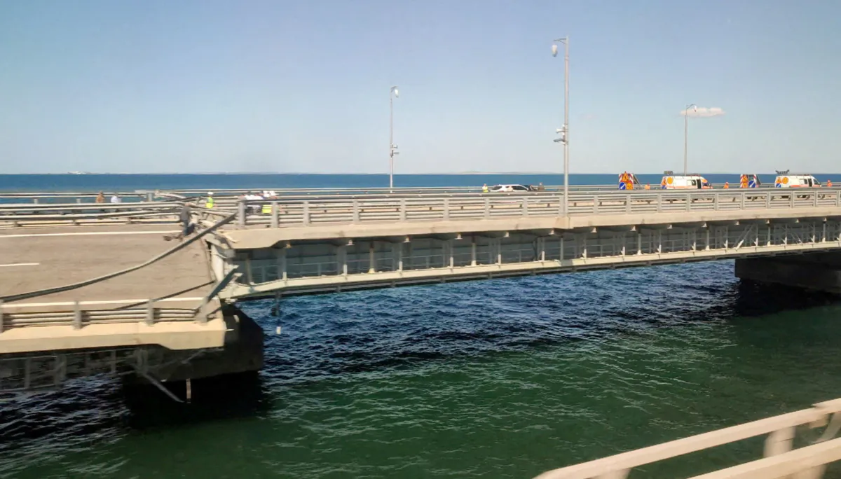 A view through a train window shows the section of a road split and sloping to one side following an alleged attack on the Crimea Bridge, that connects the Russian mainland with the Crimean peninsula across the Kerch Strait, in this still image from video taken on July 17, 2023. (Stringer/Reuters)