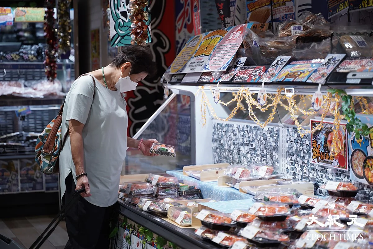 A woman is looking at the seafood section in a chained Japanese supermarket in Tsim Sha Tsui, Hong Kong on Aug. 24, 2023. (Benson Lau/The Epoch Times)