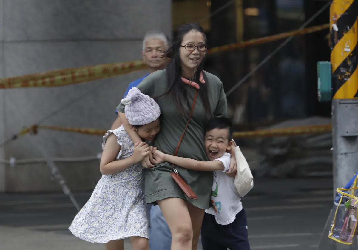 People struggle to walk against gusts of wind generated by Typhoon Haikui in Taipei, Taiwan, on Sept. 3, 2023. (Chiang Ying-ying/AP Photo)