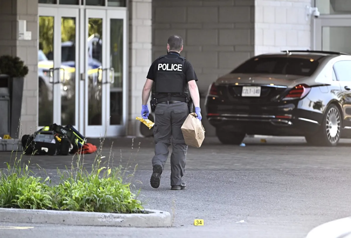 An Ottawa Police officer collects evidence after a Saturday night shooting at the Infinity Convention Centre that left two dead, in Ottawa, on Sept. 3, 2023. (The Canadian Press/Justin Tang)