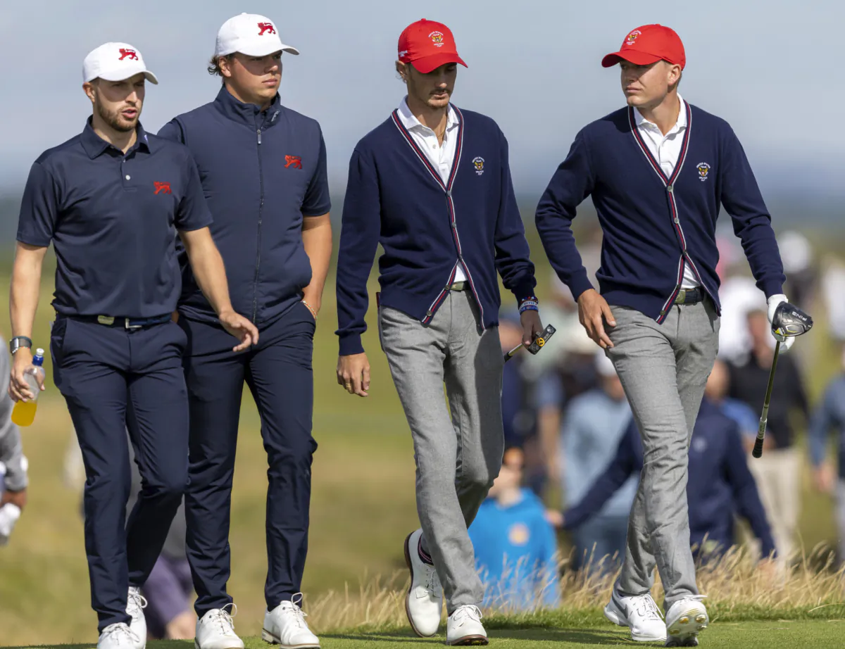 Alex Maguire, left, and James Ashfield of Great Britain and Ireland walk with Nick Gabrelcik and Preston Summerhays, right, of the USA on day two of the 2023 Walker Cup at St Andrews, Scotland, on Sept. 3, 2023. (Robert Perry/PA via AP)