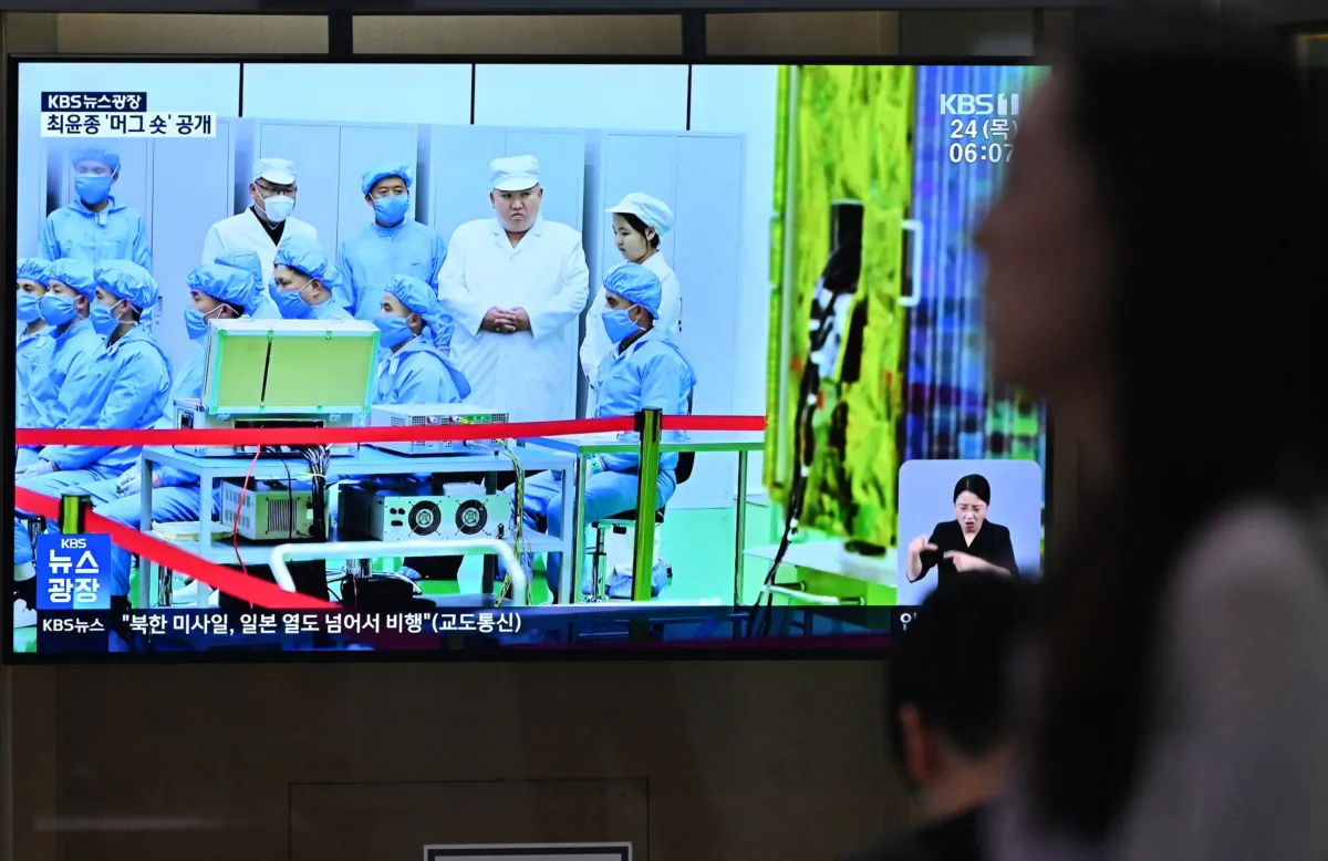 A woman walks past a television screen showing a news broadcast with file footage of North Korean leader Kim Jong Un, at a railway station in Seoul, South Korea, on Aug. 24, 2023. (Jung Yeon-je/AFP via Getty Images)