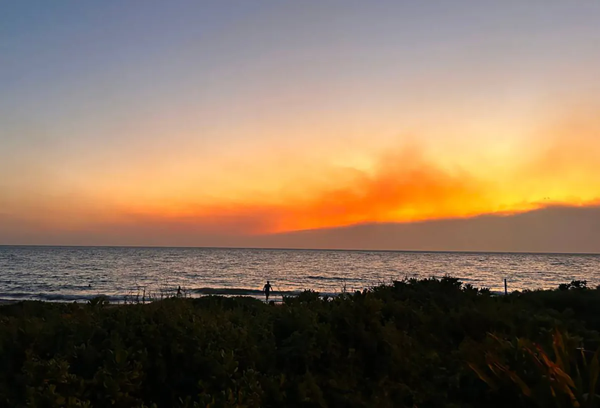 Smoke pools in the air from fires burning on Maui as the sun sets in Kihei on Tuesday, Aug. 8, 2023.