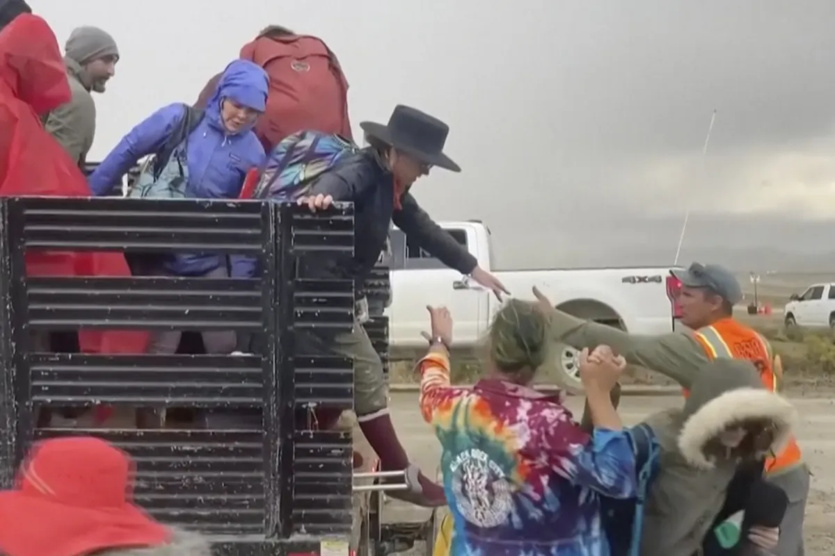 Festival goers are helped off a truck from the Burning Man festival site in Black Rock, Nev., on Sept. 4, 2023. (Stringr via AP)