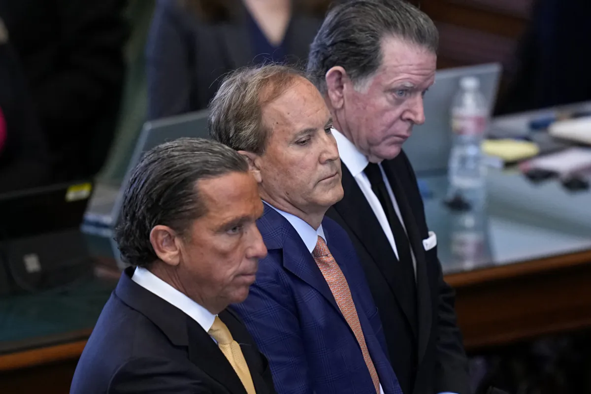 Texas state Attorney General Ken Paxton (center) stands between his attorneys Tony Buzbee (front) and Dan Cogdell (rear) as the articles of his impeachment are read during the his impeachment trial in the Senate Chamber at the Texas Capitol in Austin on Sept. 5, 2023. (Eric Gay/AP Photo)