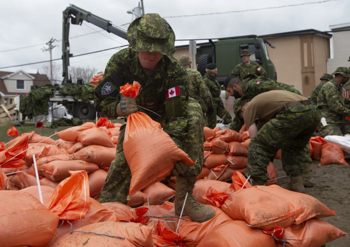 Members of the Canadian Forces prepare sandbags for distribution to residents threatened by floodwaters in Gatineau, Que, on April 24, 2019. (The Canadian Press/Adrian Wyld)