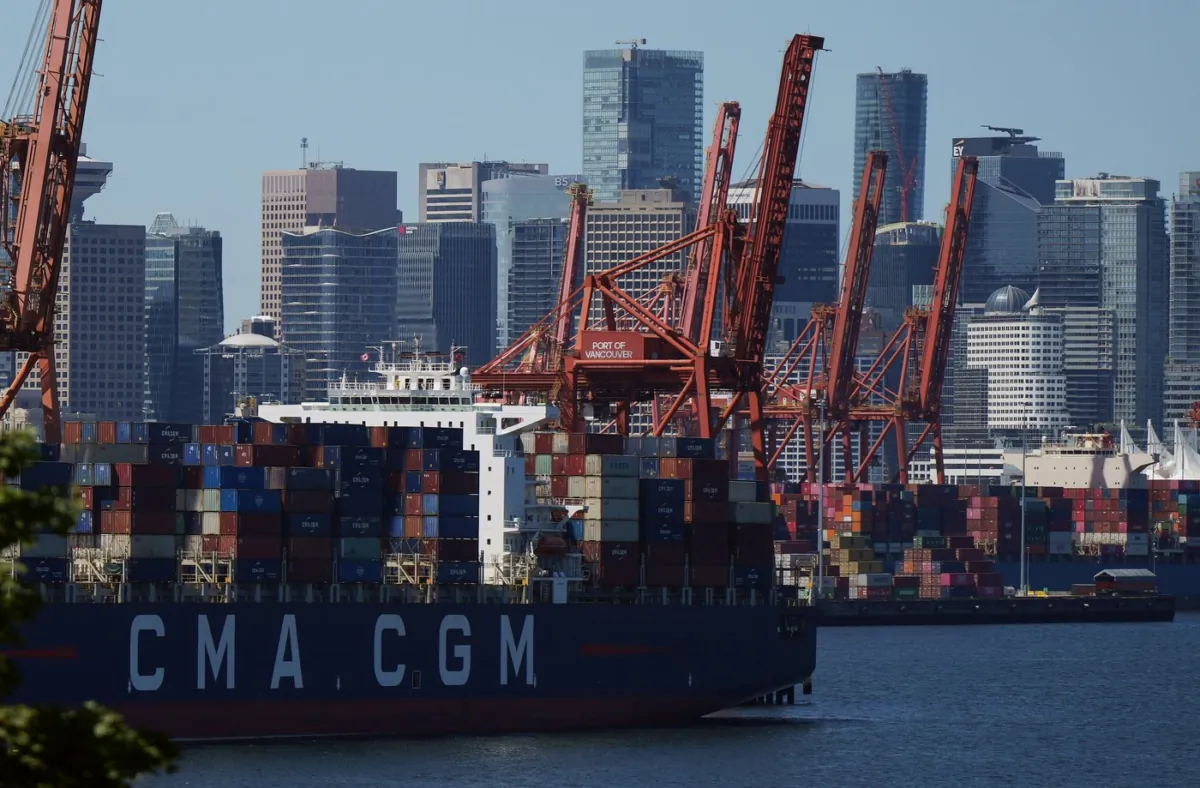 Gantry cranes sit idle as a container ship is docked at port during a work stoppage, in Vancouver, on July 19, 2023. (The Canadian Press/Darryl Dyck)