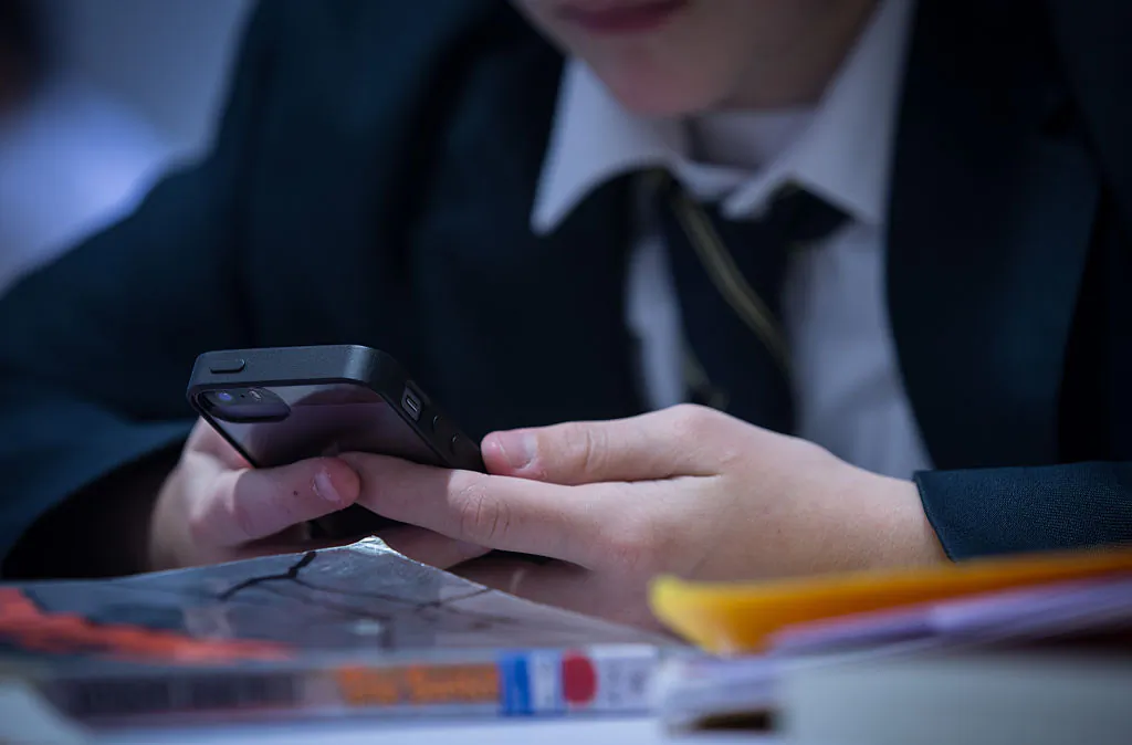 A pupil uses his mobile phone for research during a english lesson at the Ridings Federation Winterbourne International Academy in Winterbourne near Bristol on February 26, 2015. (Photo by Matt Cardy/Getty Images)