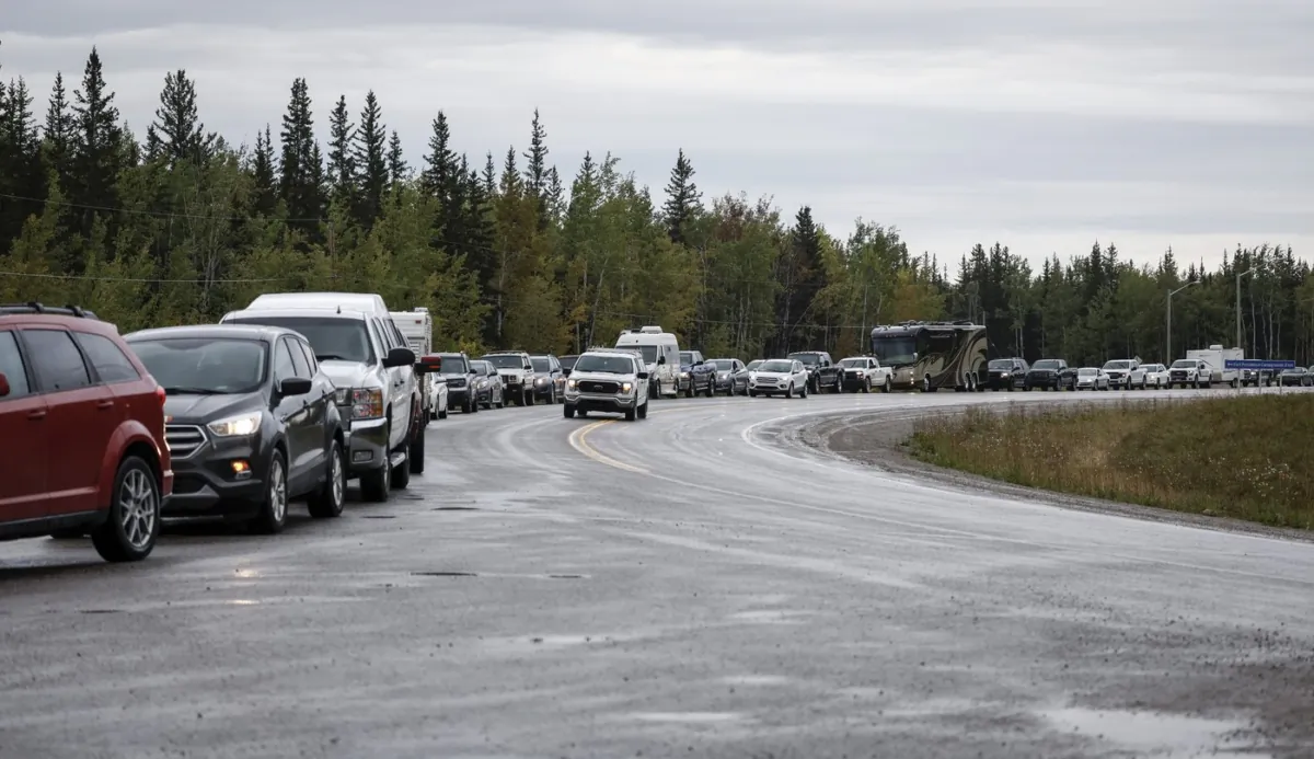 Vehicles line up for fuel at Fort Providence, N.W.T., on the only road south from Yellowknife on Aug. 17, 2023. (The Canadian Press/Jeff McIntosh)