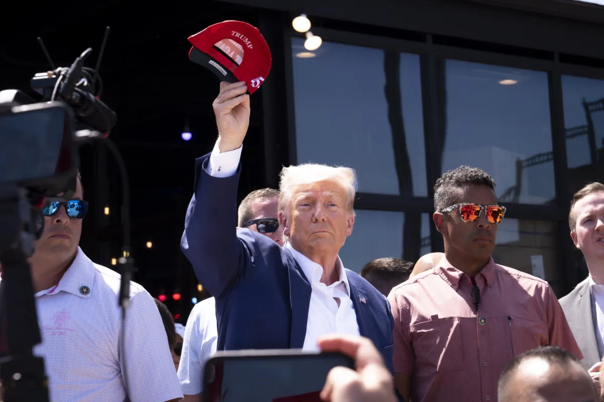 Former President Donald Trump tosses caps to the crowd at the Iowa State Fair in Des Moines, Iowa, on Aug. 12, 2023.(Madalina Vasiliu/The Epoch Times)
