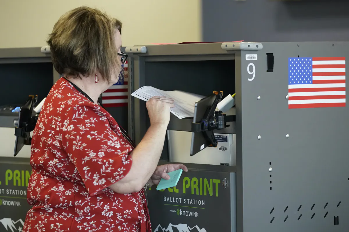 A poll worker prints a ballot for a voter at the Center Point Church in Orem, Utah, on Nov. 8, 2022. (George Frey/Getty Images)