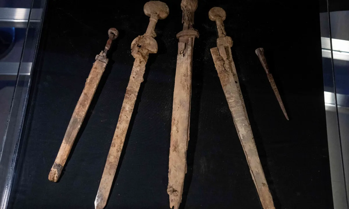 Israeli archaeologists show four Roman-era swords and a javelin head found during a recent excavation in a cave near the Dead Sea, in Jerusalem on Sep. 6, 2023. (Ohad Zwigenberg/AP Photo)