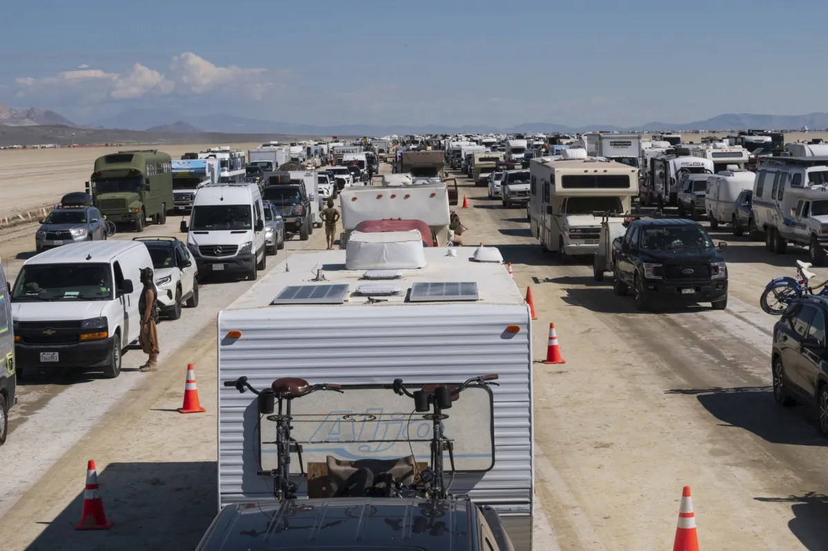 Vehicles line up to leave the Burning Man festival in Black Rock Desert, Nev., on Sept. 5, 2023. (Monique Sady via AP)