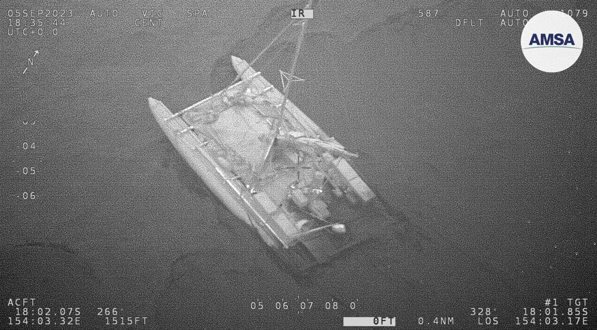 A partially submerged catamaran is shown during a rescue of 3 sailors in the Coral Sea on Sept. 6, 2023. (Australian Maritime Safety Authority via AP)
