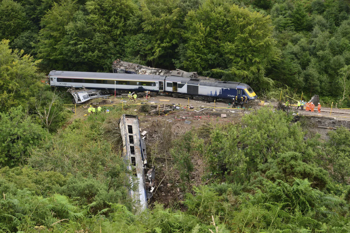 Emergency services inspect the scene near Stonehaven, Aberdeenshire, Scotland, on Aug. 13, 2020, following the derailment of the ScotRail train. (Ben Birchall/PA via AP)