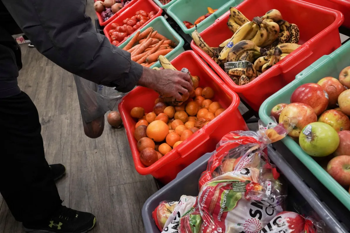 A community member grabs a piece of fruit at The Community Assistance Center food pantry, in Atlanta, Ga., on April 12, 2023. (Megan Varner/Reuters)