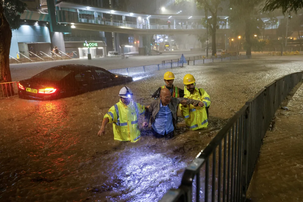 Drainage workers assist a driver stranded due to flooding to a safe place during heavy rain in Hong Kong on Sept. 8, 2023. (Tyrone Siu/Reuters)