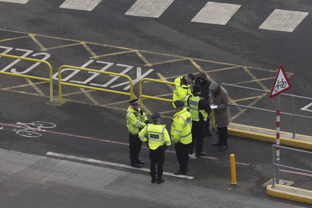 Kent Police officers question two men after finding them in the back of a lorry queuing to enter Dover port to board a ferry to mainland Europe in Dover, England, on Jan. 11, 2022. (Dan Kitwood/Getty Images)