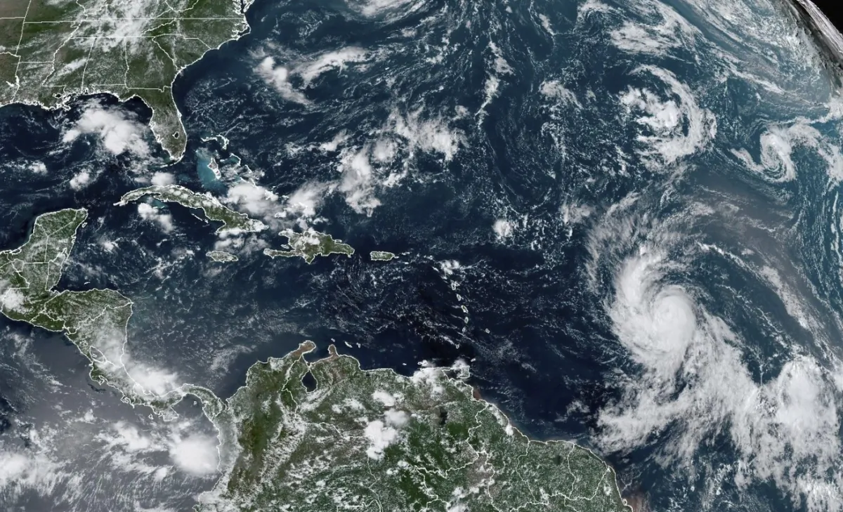 Satellite image provided by the National Oceanic and Atmospheric Administration shows Hurricane Lee, right, off in the central tropical Atlantic Ocean on Sept. 6, 2023. (NOAA via AP)