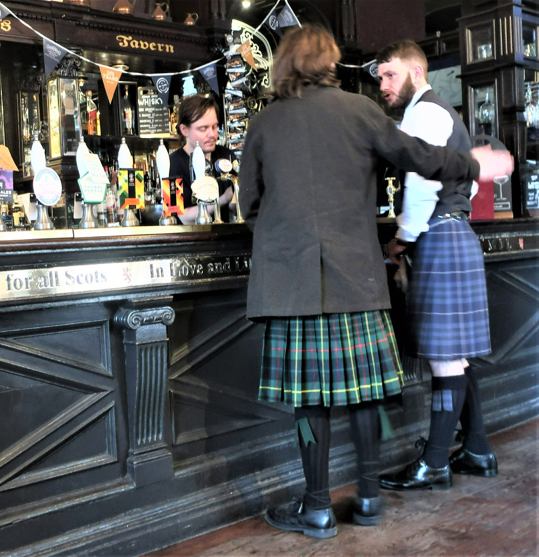 People in kilts at a pub