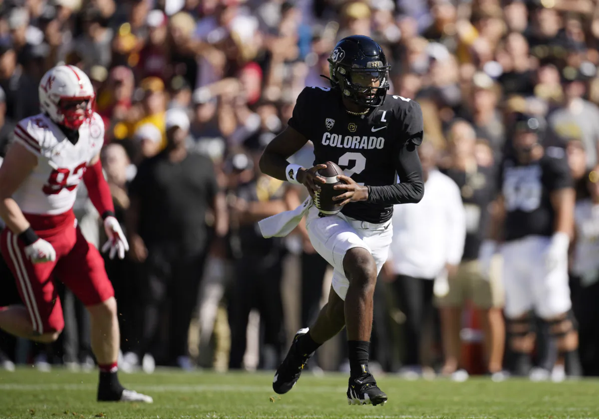Colorado quarterback Shedeur Sanders, right, runs for a short gain as Nebraska defensive lineman Kai Wallin pursues in the first half of an NCAA college football game in Boulder, Colo., Sept. 9, 2023. (David Zalubowski/AP Photo)