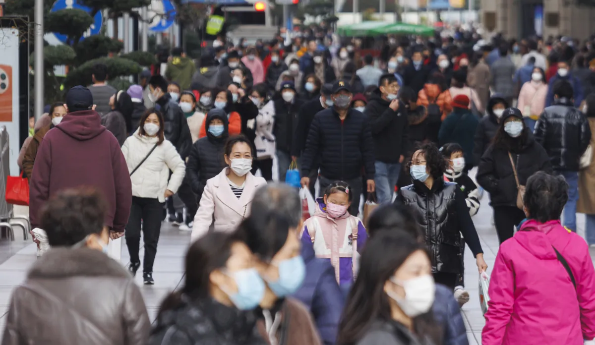 People with protective masks walk at Nanjing road in Shanghai on Dec. 11, 2022. (Hu Chengwei/Getty Images)