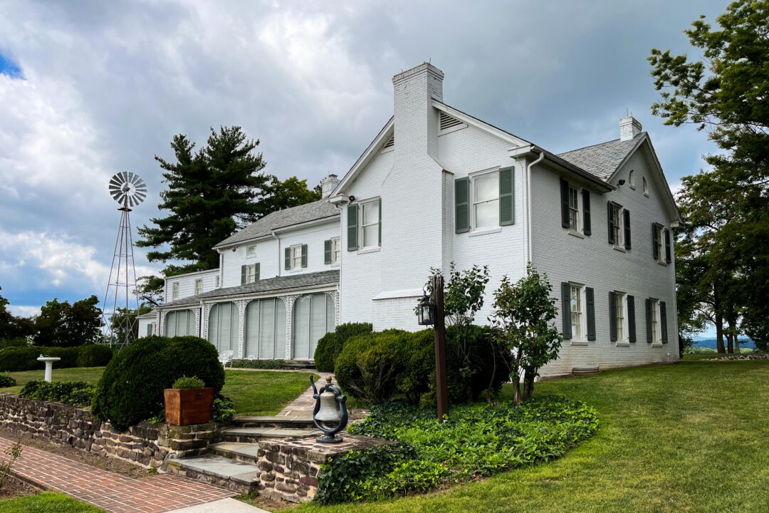 The back view of the Eisenhower farmhouse overlooking a flagpole with a five-star flag, signifying his military rank, and a putting green. (Lynn Topel)