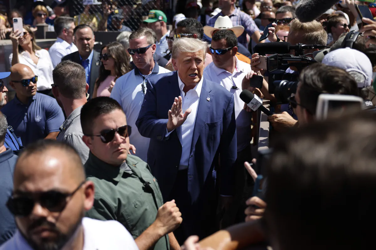 Surrounded by campaign staff and members of the U.S. Secret Service, former President Donald Trump (C) waves to supporters in a file photo. (Chip Somodevilla/Getty Images)