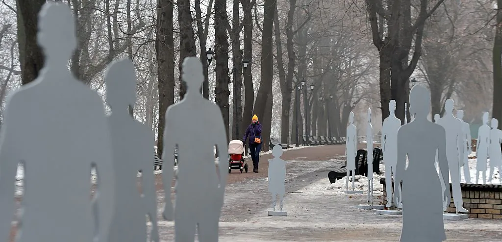 People stroll on Dec. 16, 2014, in a park among figures set as part of an installation called Invisible in Plain Sight in the centre of Kyiv to raise awareness about human trafficking and recount stories of the victims who live among us. (Sergei Supinsky/AFP via Getty Images)