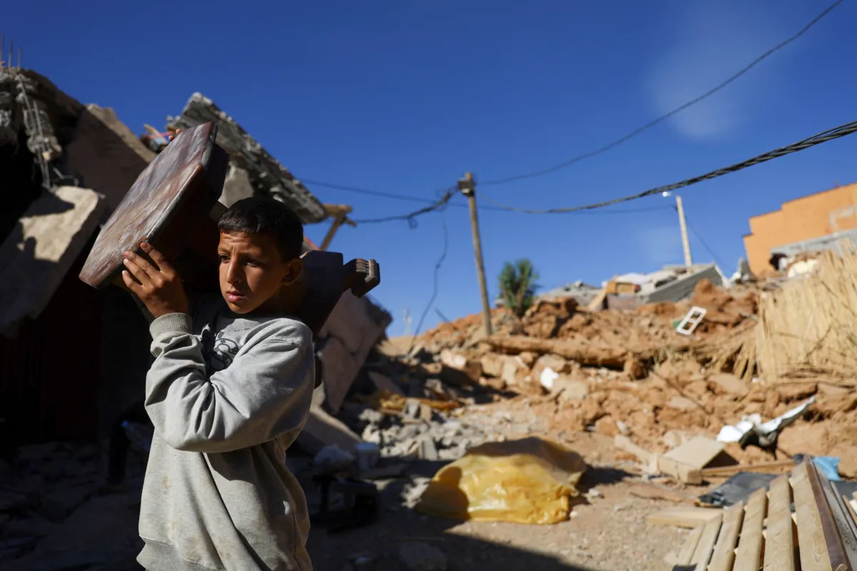 A person carries an item of furniture, in the aftermath of a deadly earthquake, in a hamlet on the outskirts of Talaat N'Yaaqoub, Morocco, on Sept. 11, 2023. (Hannah McKay/Reuters)
