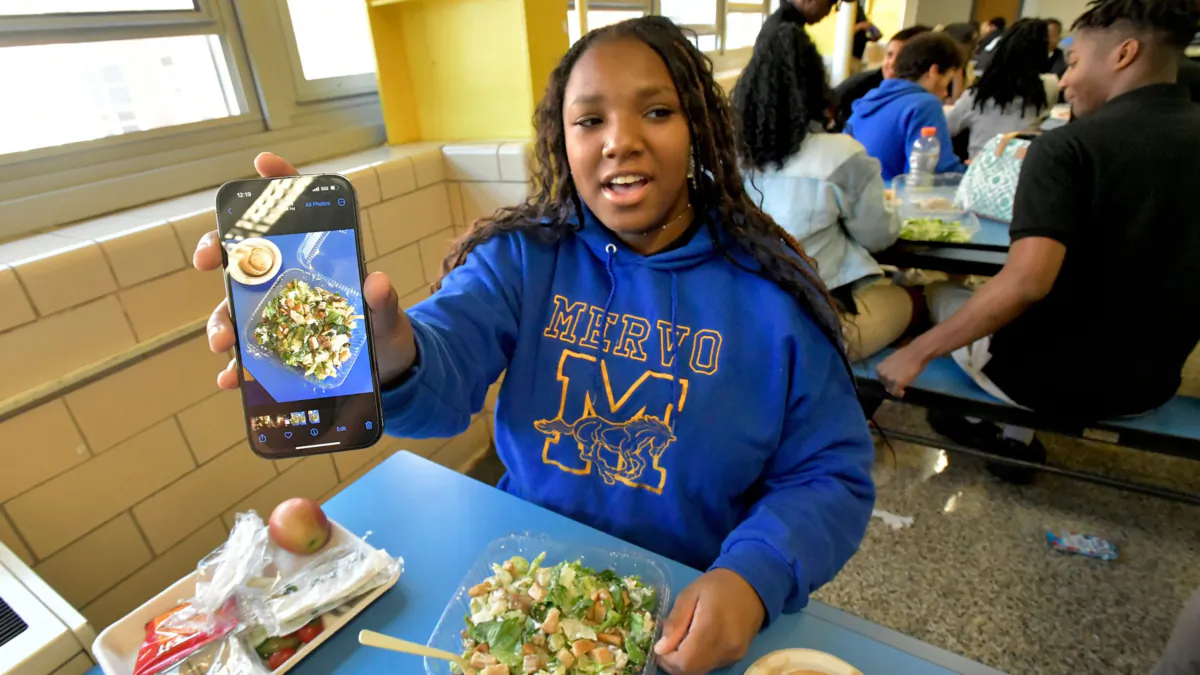 Kamiara West, a senior in the culinary program at Mergenthaler Vocational-Technical High School, photographs and rates her school lunches on an Instagram account. She is documenting her chicken Caesar salad and garlic knot, after she removed the cucumbers and cherry tomatoes. (Amy Davis/The Baltimore Sun/TNS)