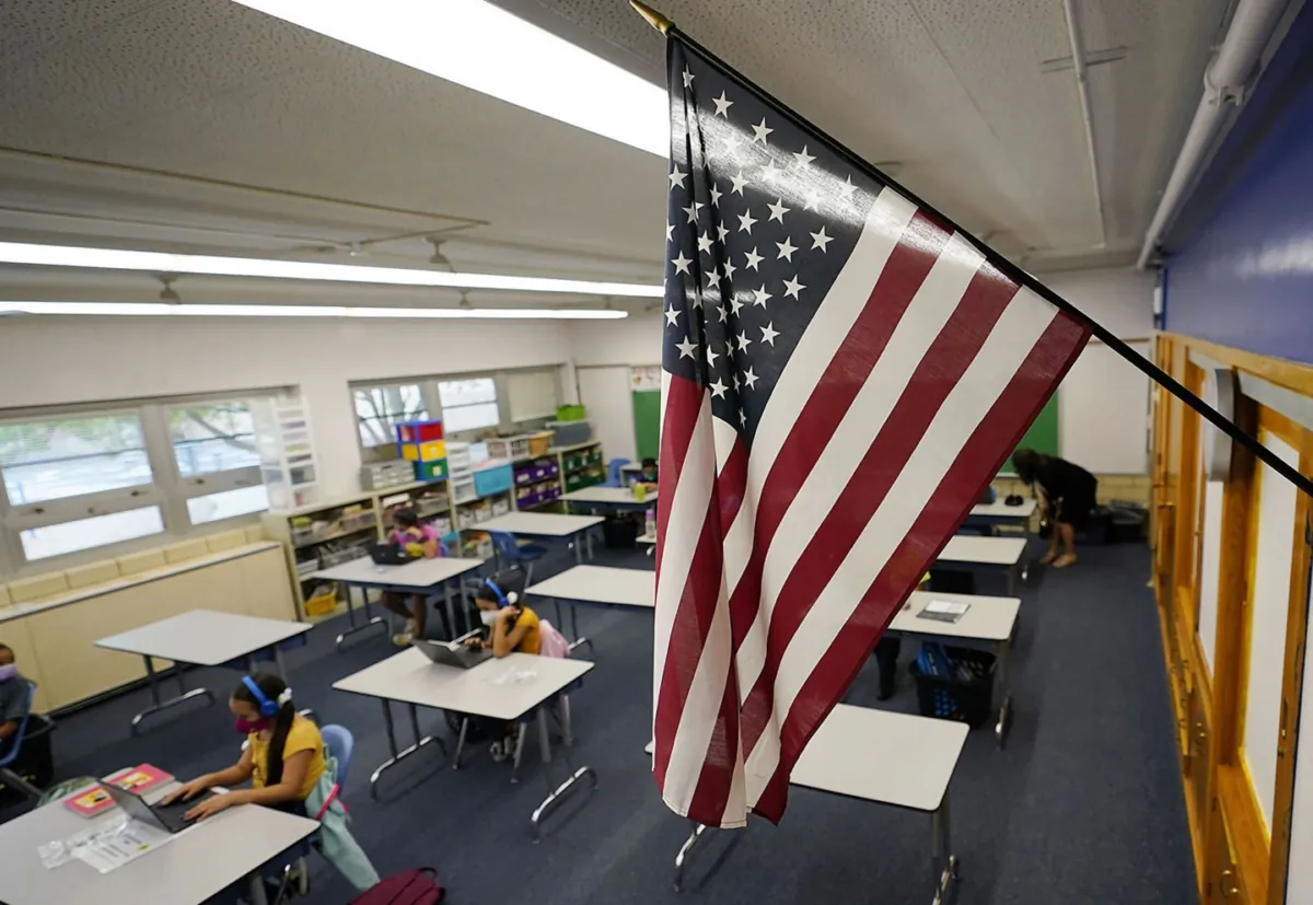 A U.S. flag hangs in a classroom as students work on laptops in Newlon Elementary School in Denver, Colo., in a file photo. (David Zalubowski/AP Photo)