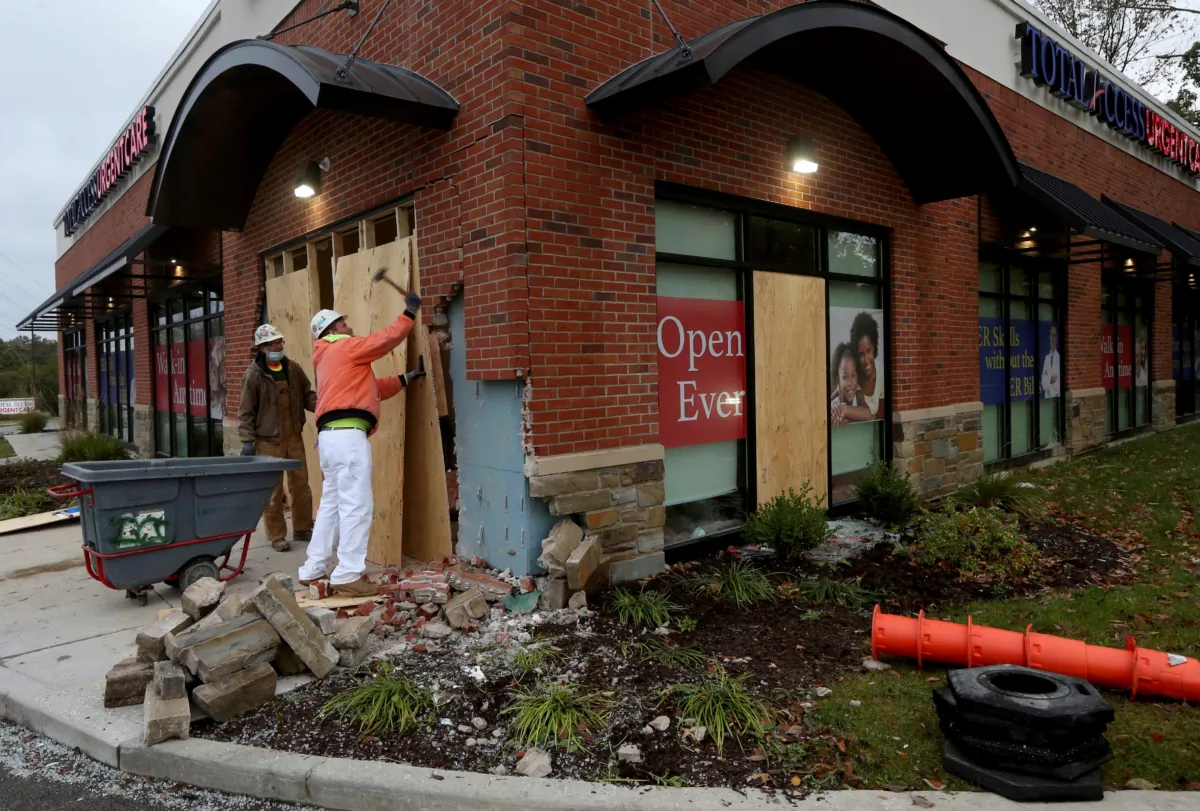Louis Kloeppel, with Interface Construction, demolishes part of a damaged wall so repairs can begin at the Total Access Urgent Care in Chesterfield, Mo., on Oct. 19, 2020. (Laurie Skrivan/St. Louis Post-Dispatch via AP)