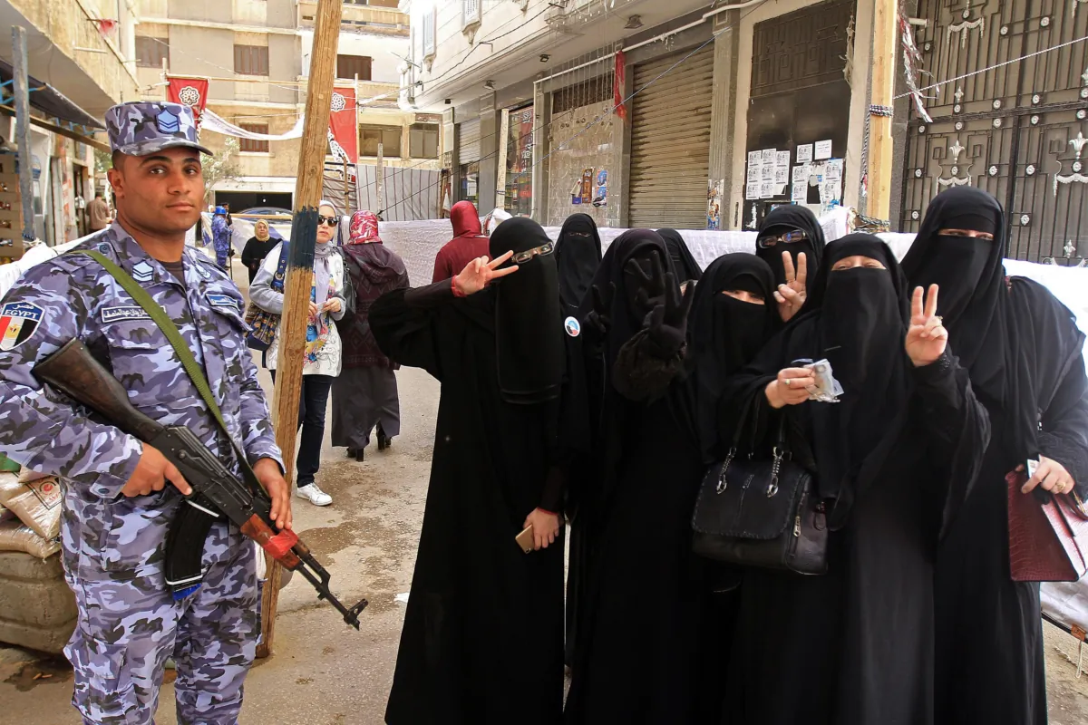 Egyptian women wearing niqab (full face veils) flash the victory gesture as they pose for a group picture outside a polling station in al-Montazah district of Egypt's second city of Alexandria on the first day of voting in the 2018 presidential election on March 26, 2018. (STRINGER/AFP via Getty Images)