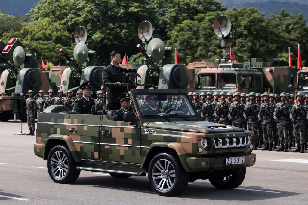 Chinese leader Xi Jinping (standing in vehicle) inspects People's Liberation Army (PLA) soldiers at a military base in Hong Kong on June 30, 2017. (Dale de la Rey/AFP via Getty Images)