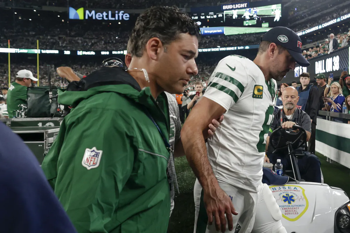 New York Jets quarterback Aaron Rodgers (8) is helped off the field during the first quarter of an NFL football game against the Buffalo Bills in East Rutherford, N.J., on Sept. 11, 2023. (Adam Hunger/AP Photo)