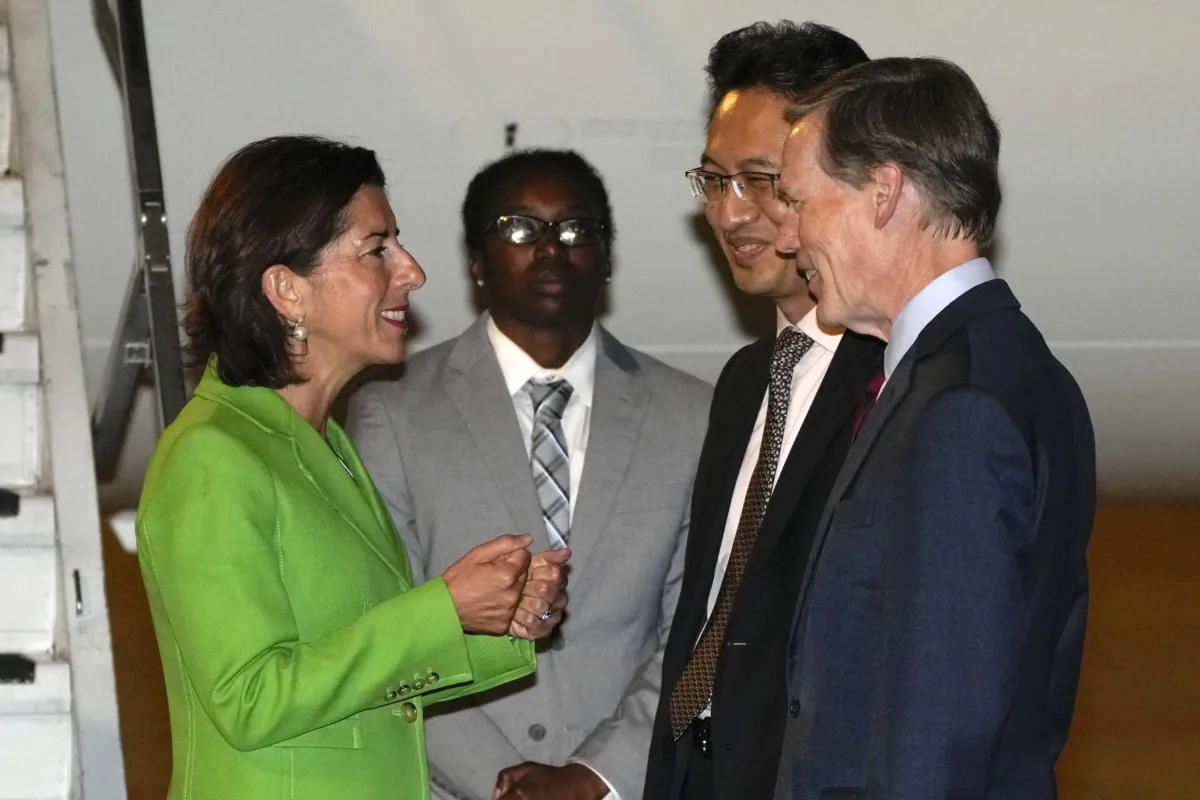 Commerce Secretary Gina Raimondo (L) chats with Lin Feng, director general of China's Ministry of Commerce (2nd R), and U.S. Ambassador to China Nick Burns (R) upon arrival at the Beijing Capital International Airport in China on Aug. 27, 2023. (Andy Wong/Pool/Getty Images)