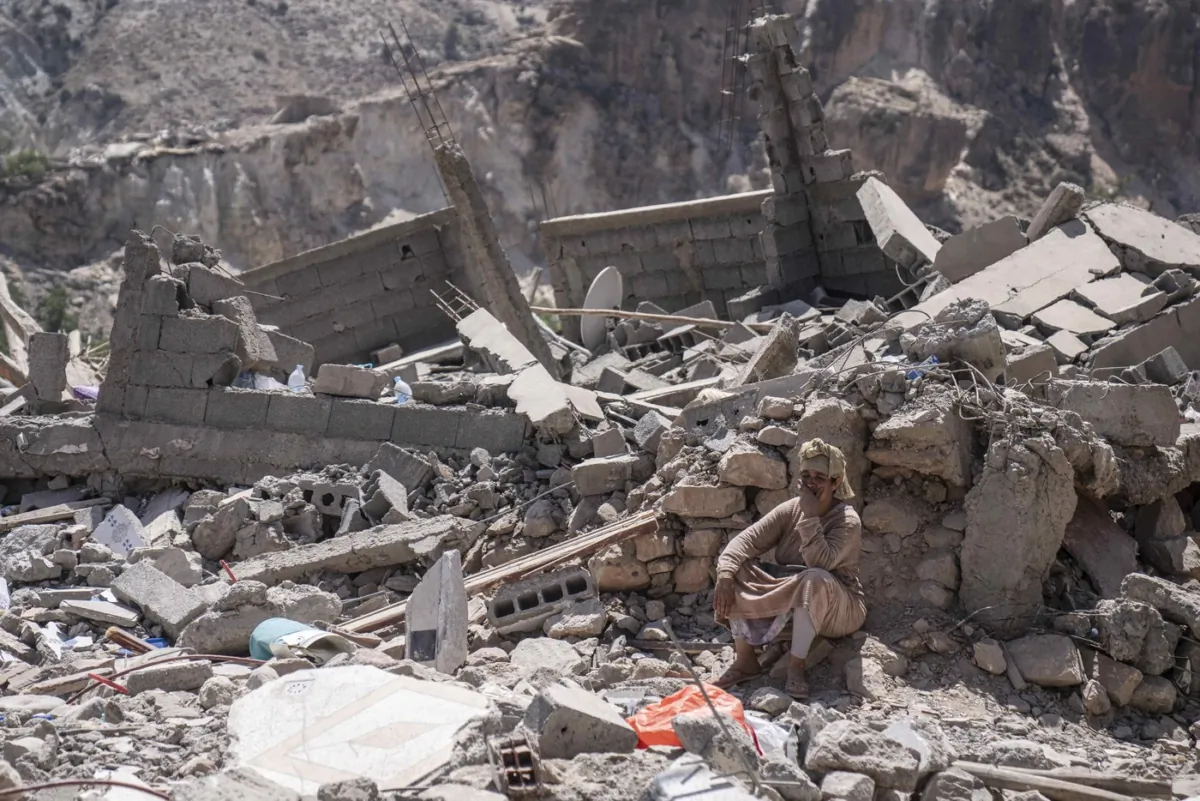 A person sits among wreckage caused by an earthquake in the town of Imi N'tala, outside Marrakech, Morocco, on Sept. 12, 2023. (The Canadian Press/AP/Mosa'ab Elshamy)