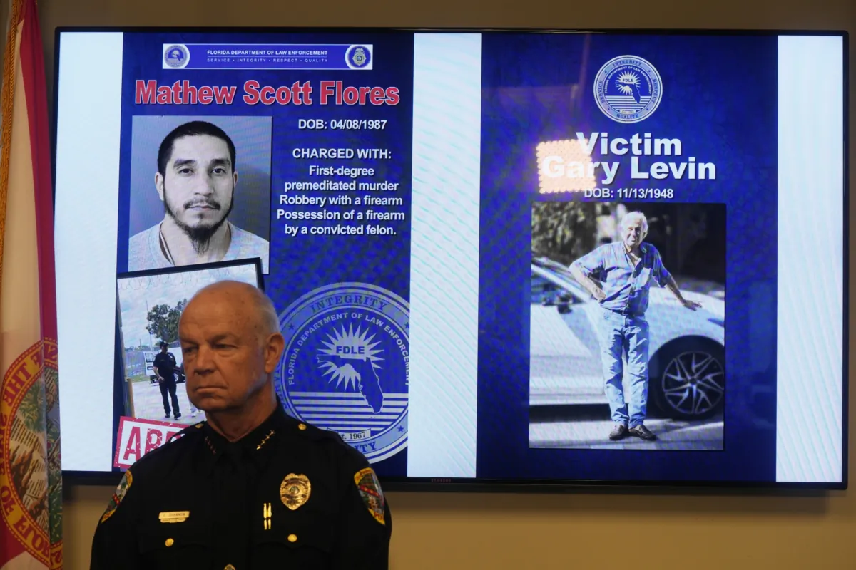 Palm Beach Gardens Chief of Police Clinton Shannon stands near an electric board showing photos of Matthew Flores and Gary Levin during a news conference in Boynton Beach, Fla., on Sept. 13, 2023. (Marta Lavandier/AP Photo)