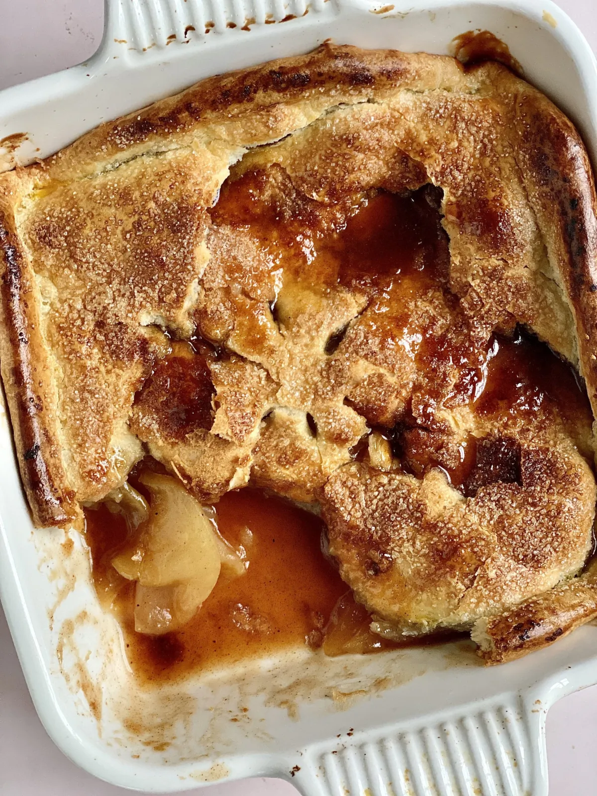 Brown sugar-sweetened apples baked under a pastry crust that has been broken into syrup-coated pieces. (Kelli Foster/TNS)